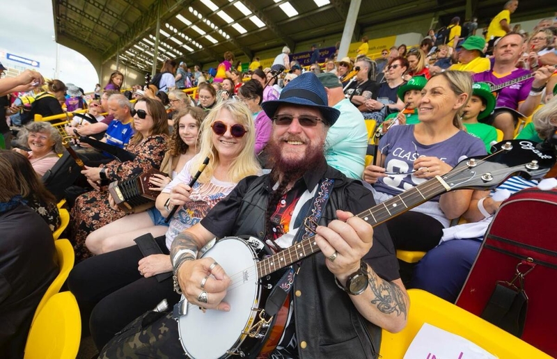 A man in a crowd holding a banjo.