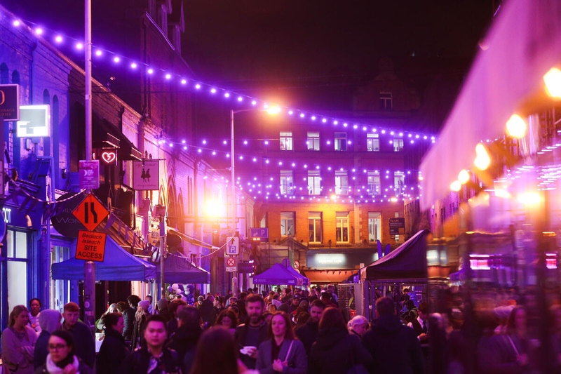 Dublin street at night with lights and festivities